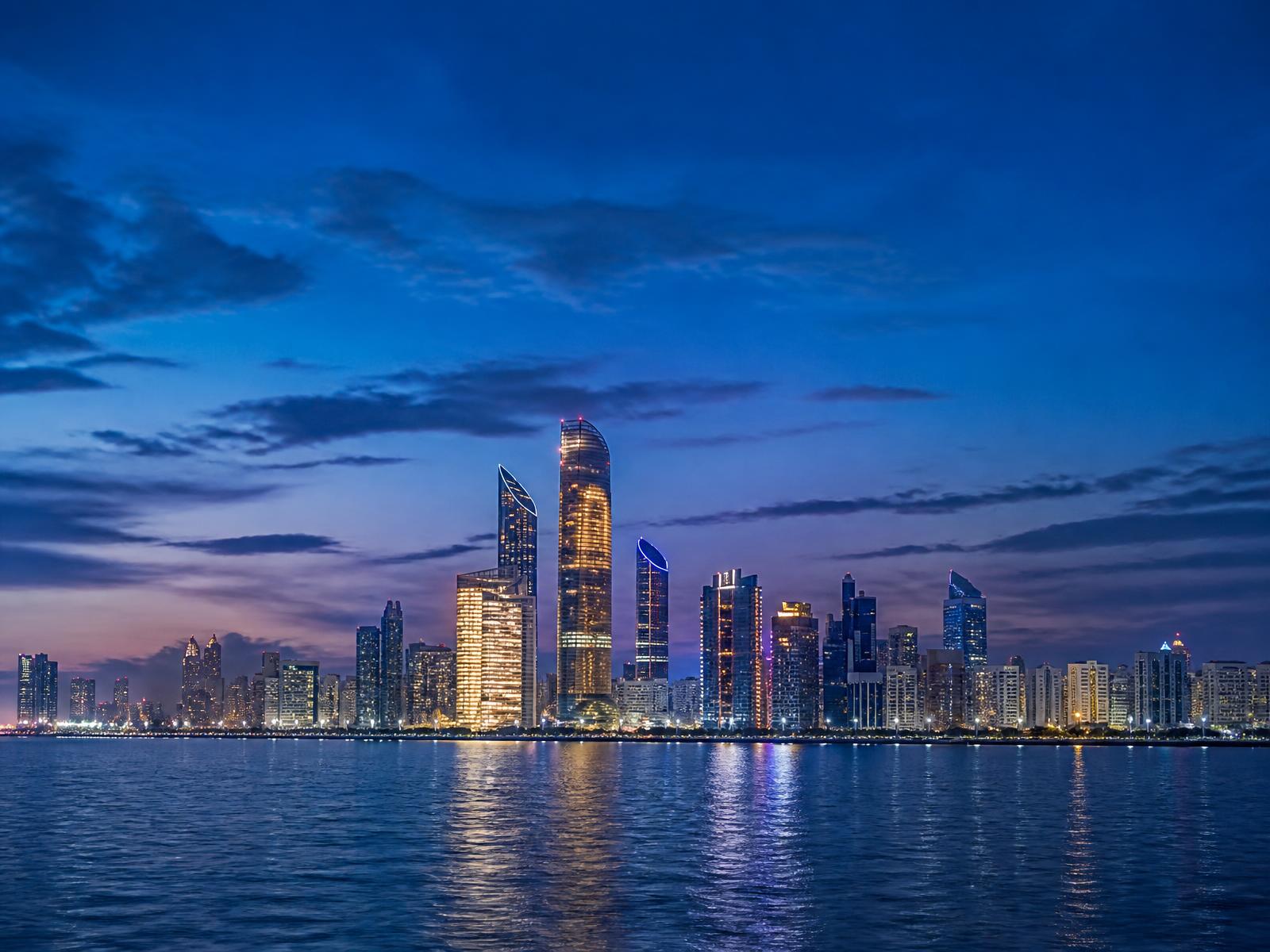 Abu Dhabi skyline at blue hour across the water